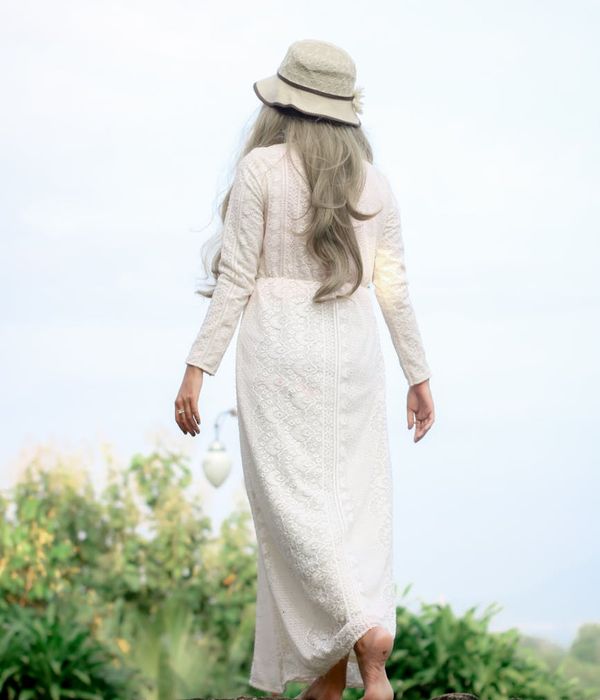 Person stretching gently outdoors with a soft, natural background light.